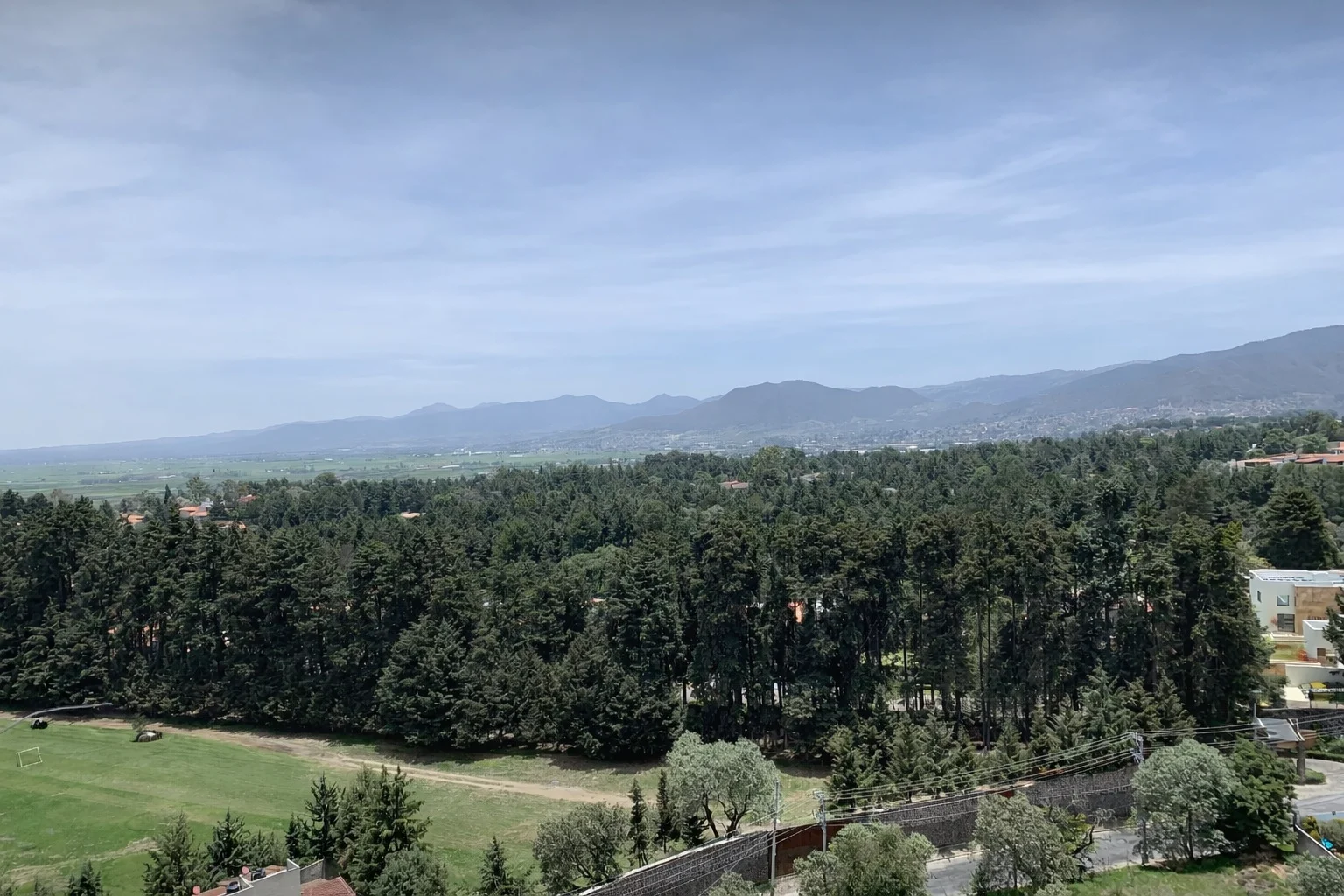 Vista panorámica desde la torre hacia el Club de Golf Los Encinos, el bosque de pinos y las montañas del valle
