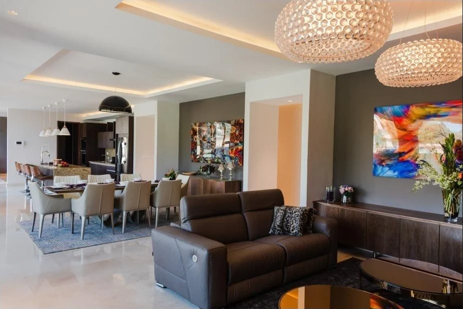 Sala y comedor en plano abierto con candelabros esféricos y ventanales al fondo