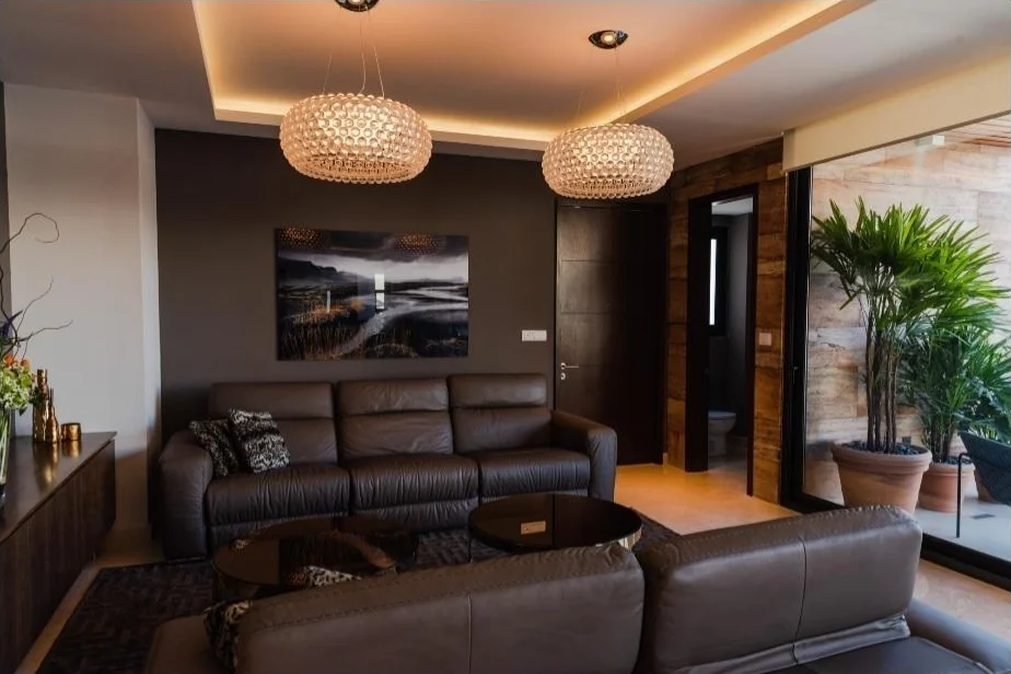 Sala de estar con sillones de piel café y doble candelabro