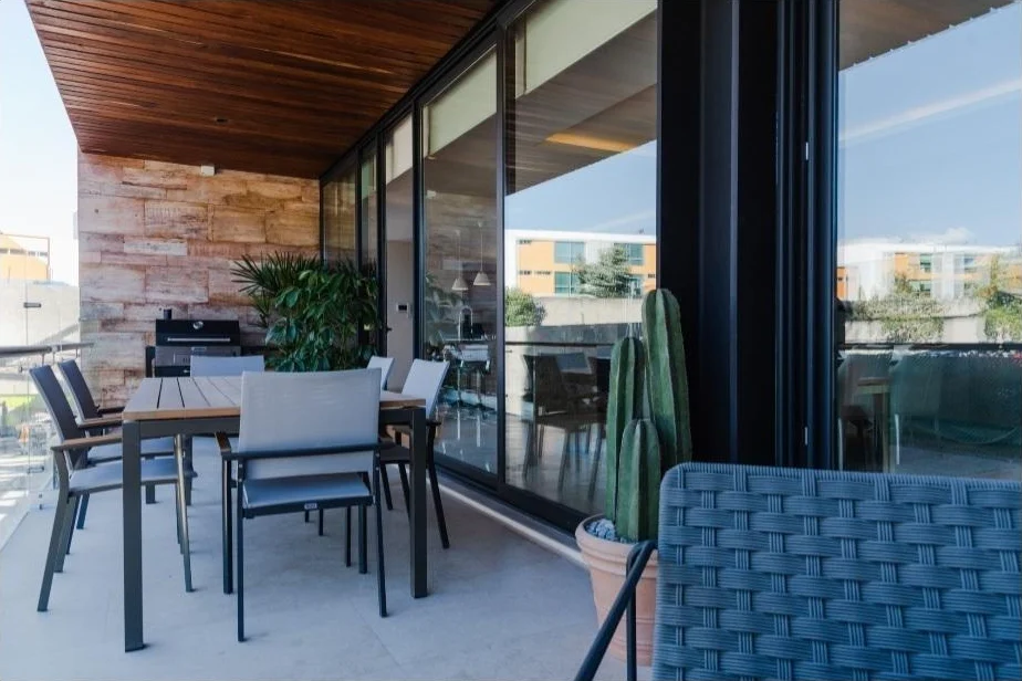 Terraza cubierta con plafón de madera, comedor exterior y asador